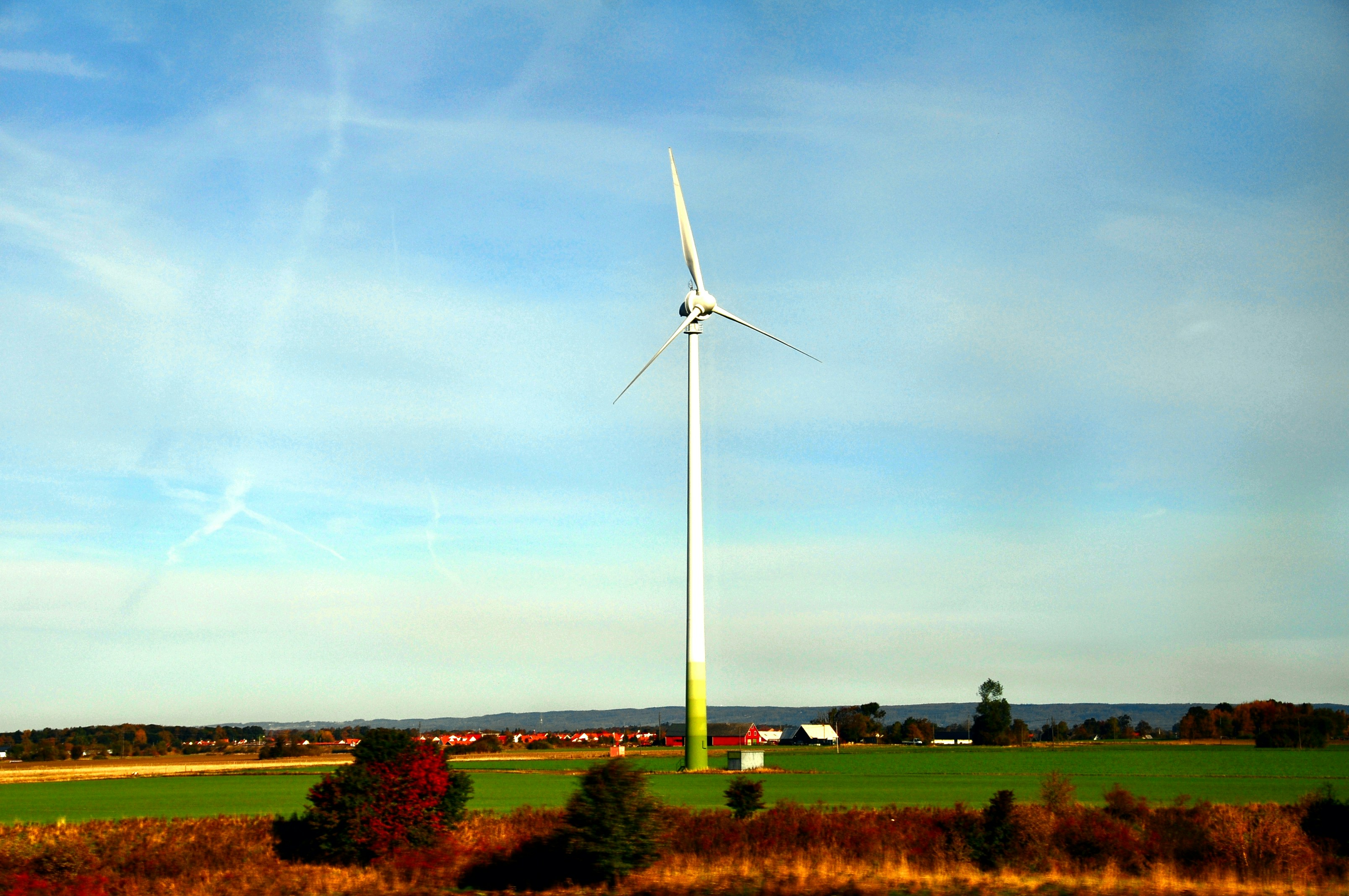A single wind turbine stands tall in a field.