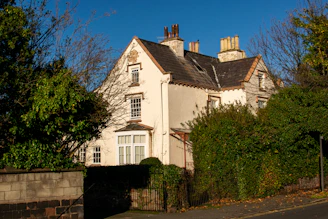 A white house surrounded by green trees.