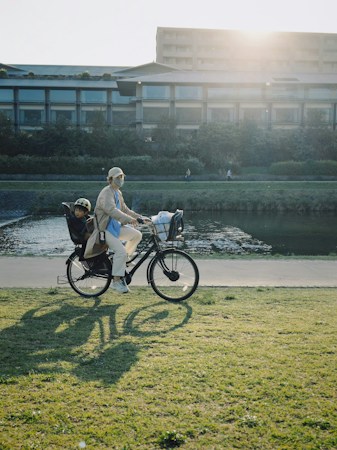 Woman riding a bicycle with a child in a rear seat, the kind of family ride a separated beltway trail in North Las Vegas makes easier
