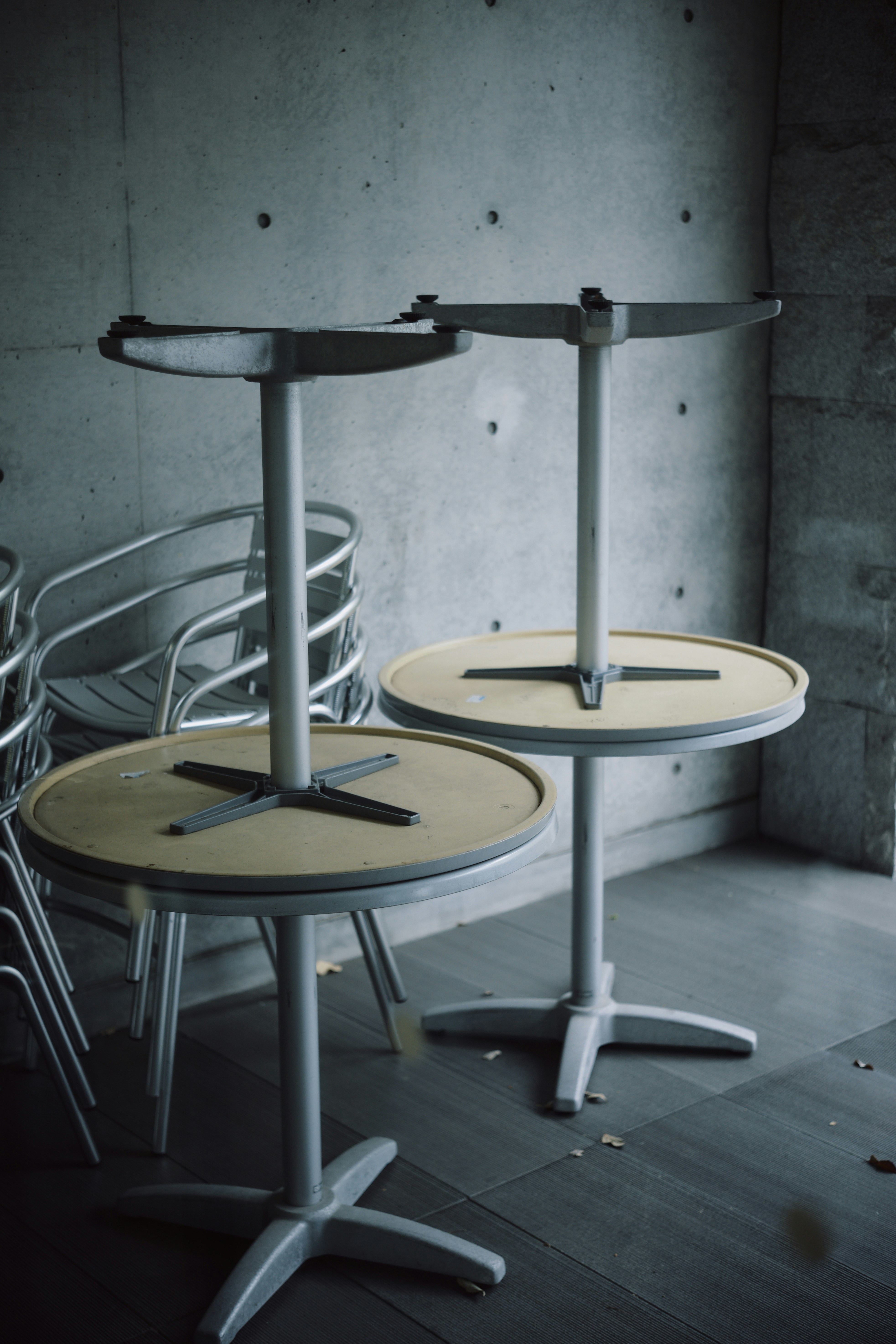 Dos mesas redondas vacías con bases metálicas