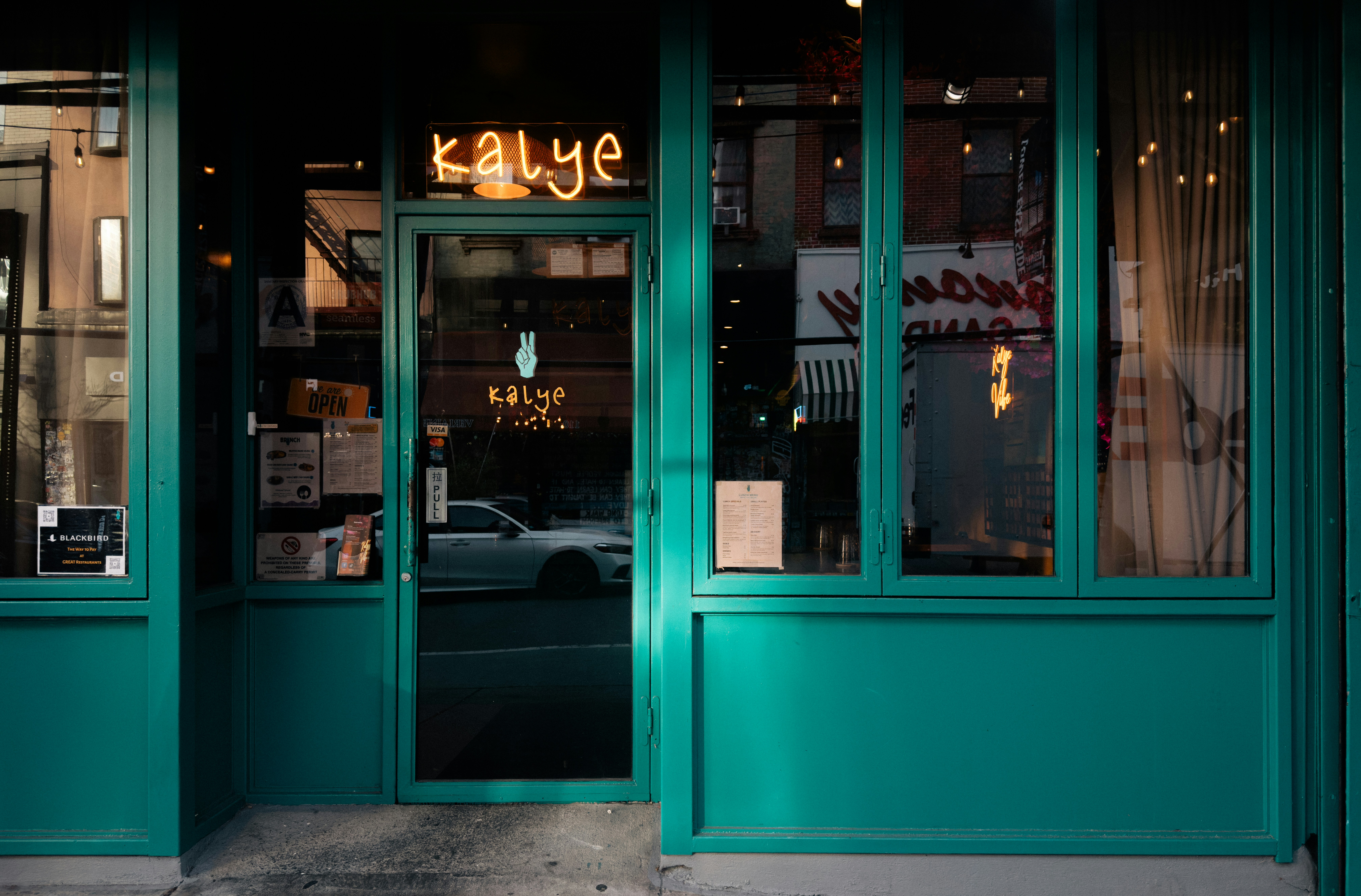 Teal storefront with neon sign for Urban Spice Hut restaurant