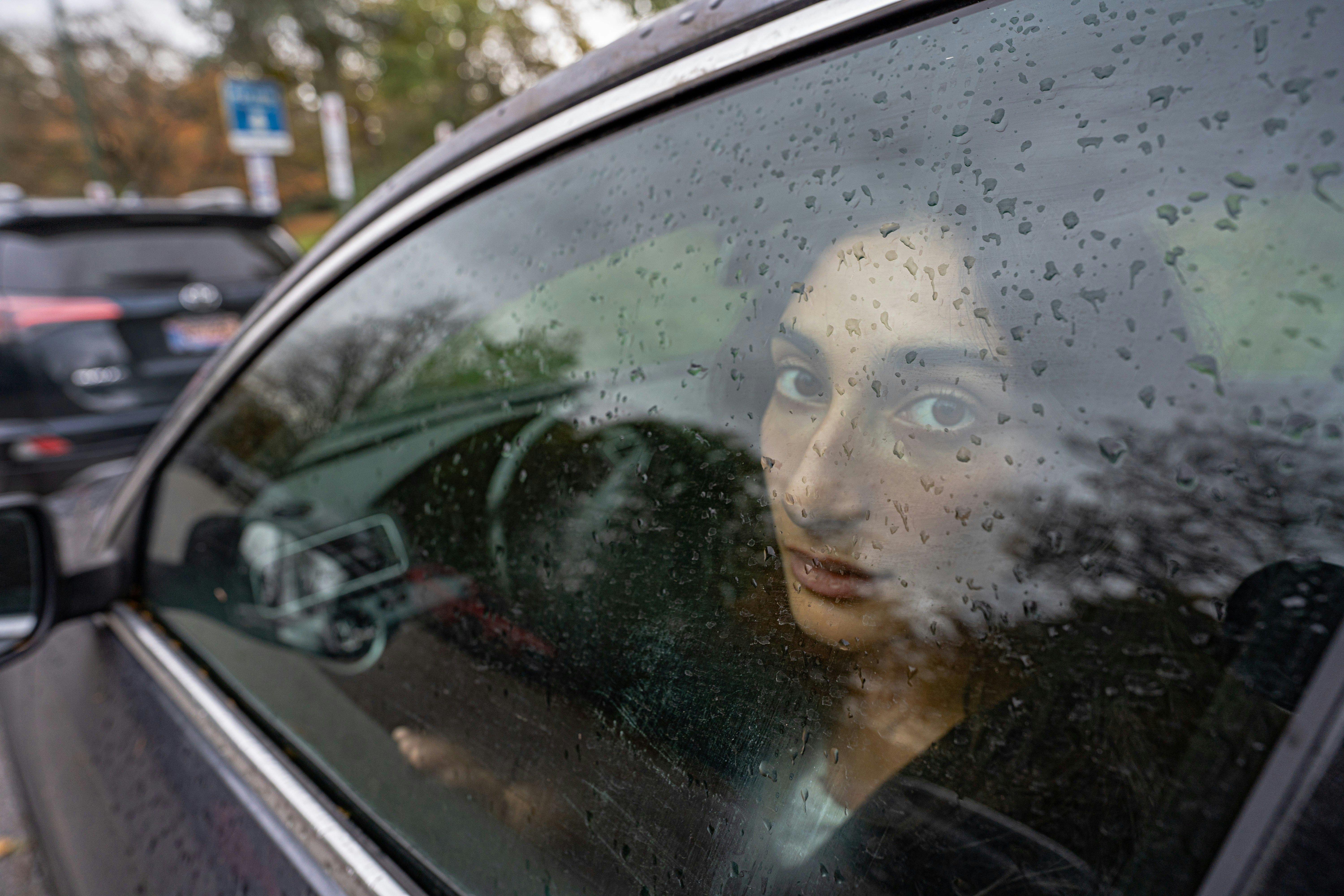 Frau, die an einem Regentag aus dem Autofenster schaut