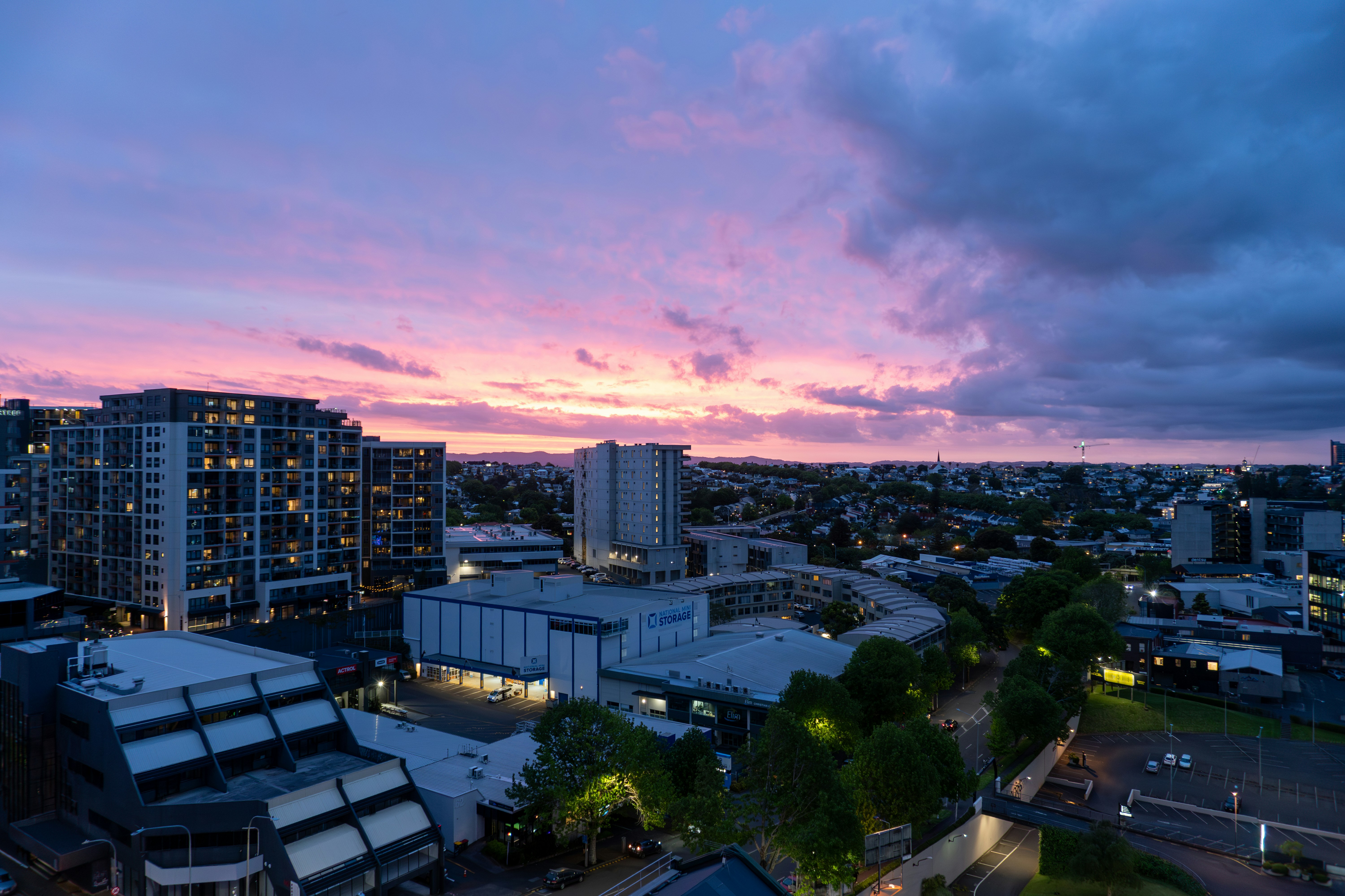 City skyline under a dramatic purple and pink sunset.