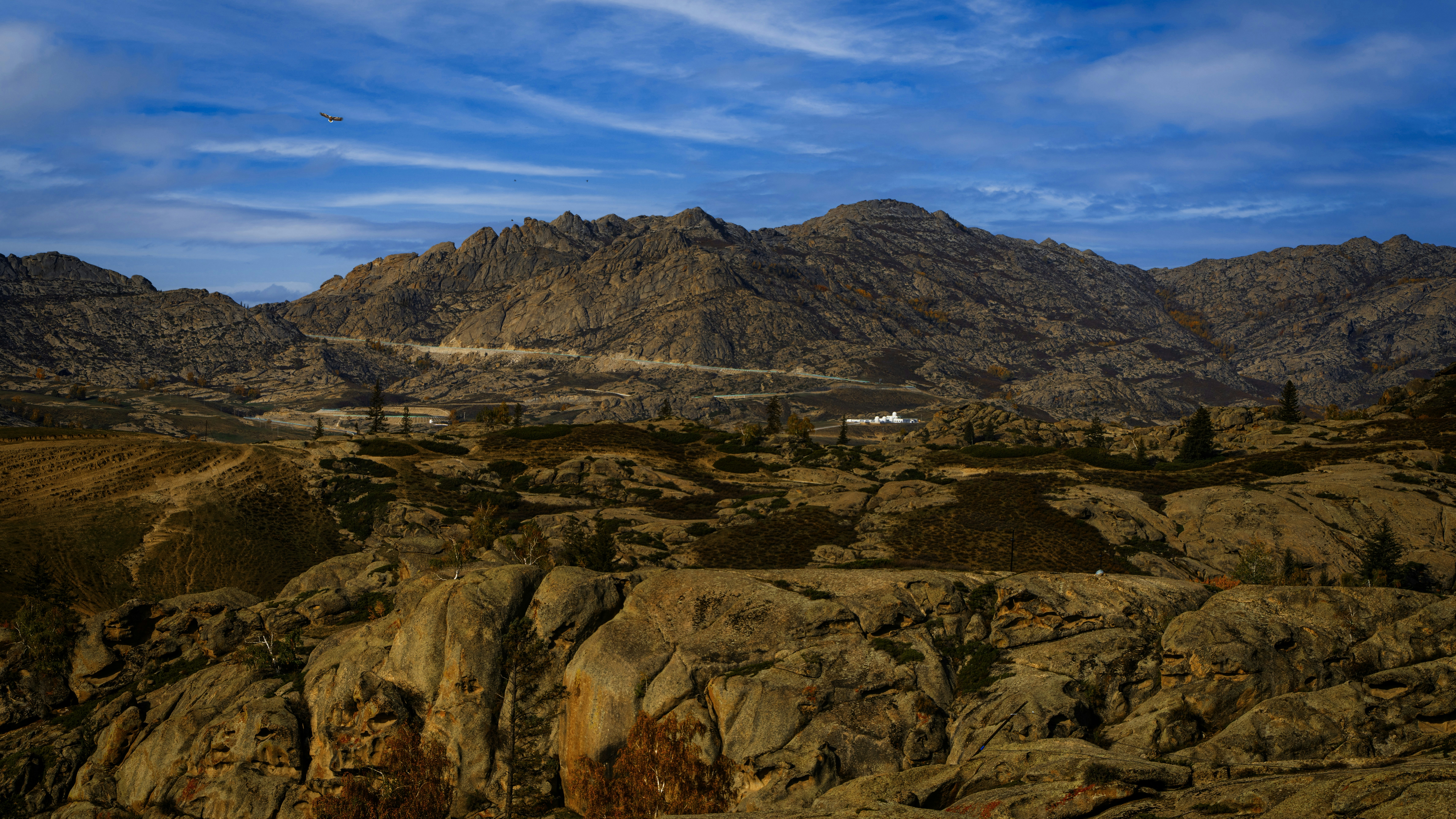 Rocky mountains under a cloudy blue sky