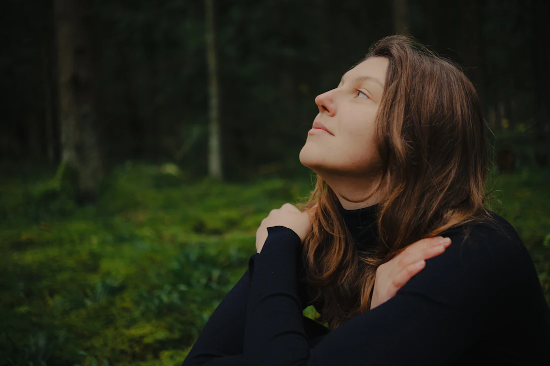 Woman with eyes closed, calm and peaceful in a forest