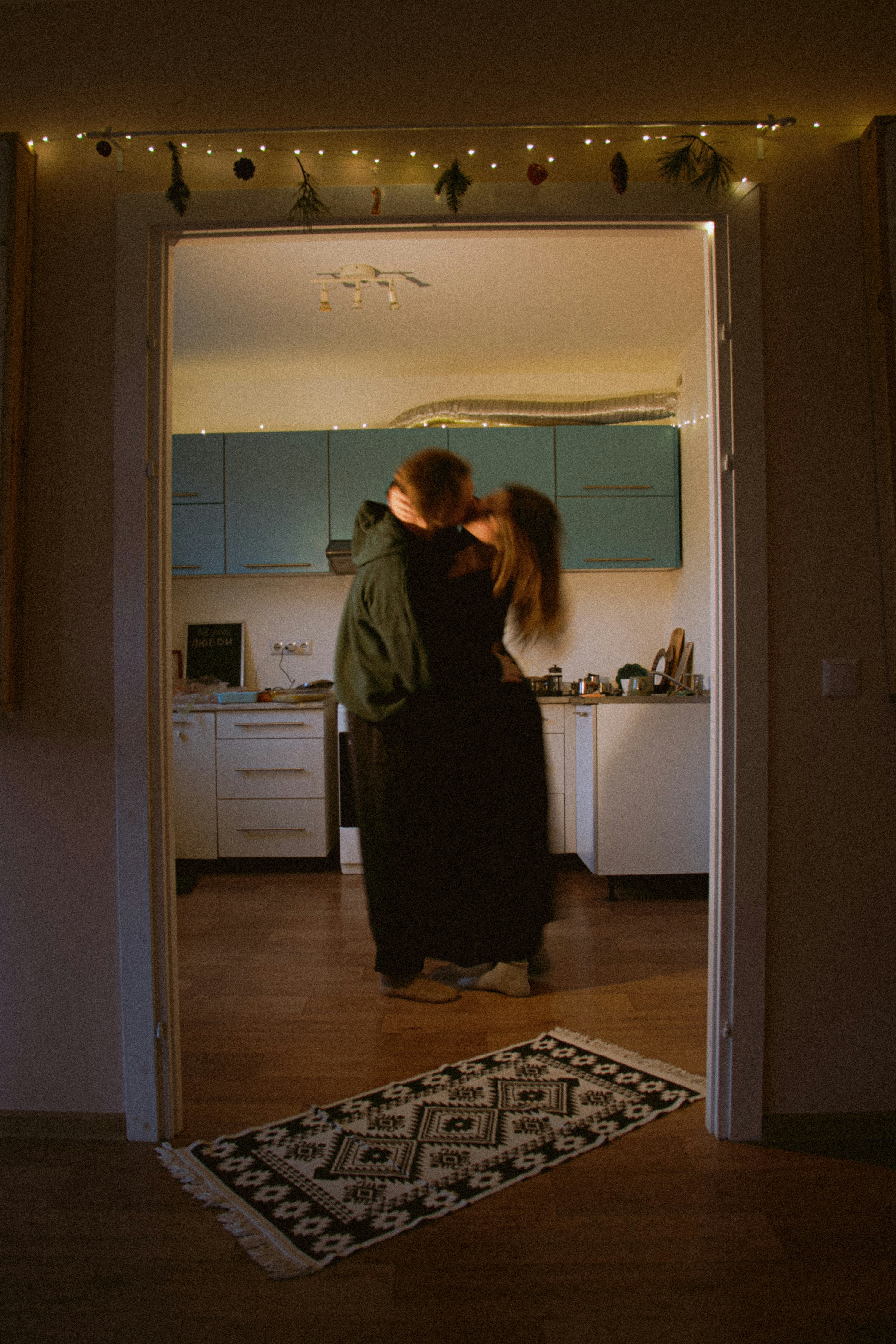 Couple embracing in a dimly lit kitchen