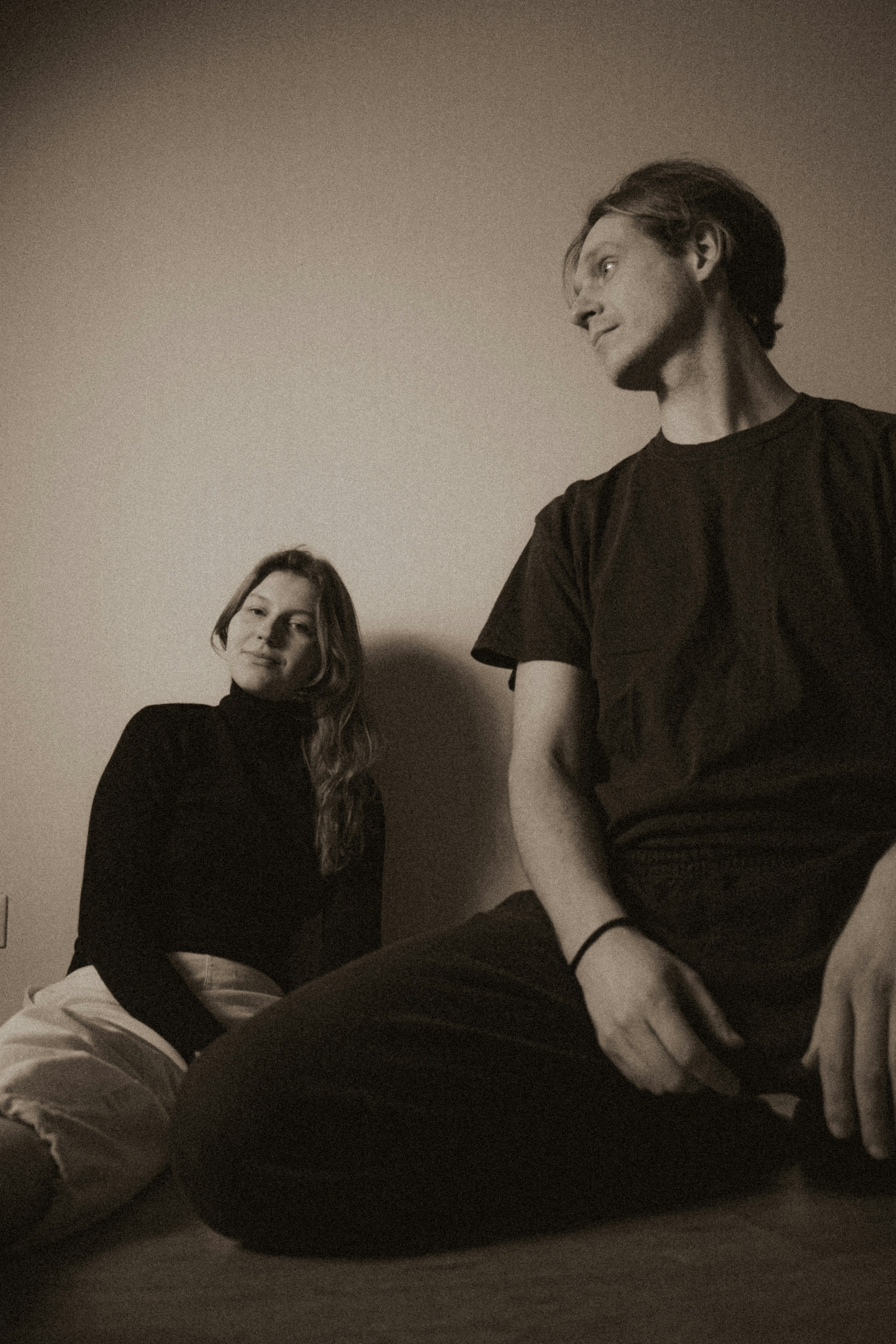 Couple sitting on the floor looking away