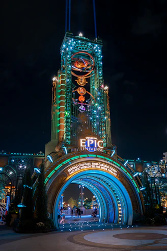 Illuminated entrance archway to epic universe at night