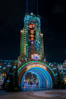 Illuminated entrance archway to epic universe at night
