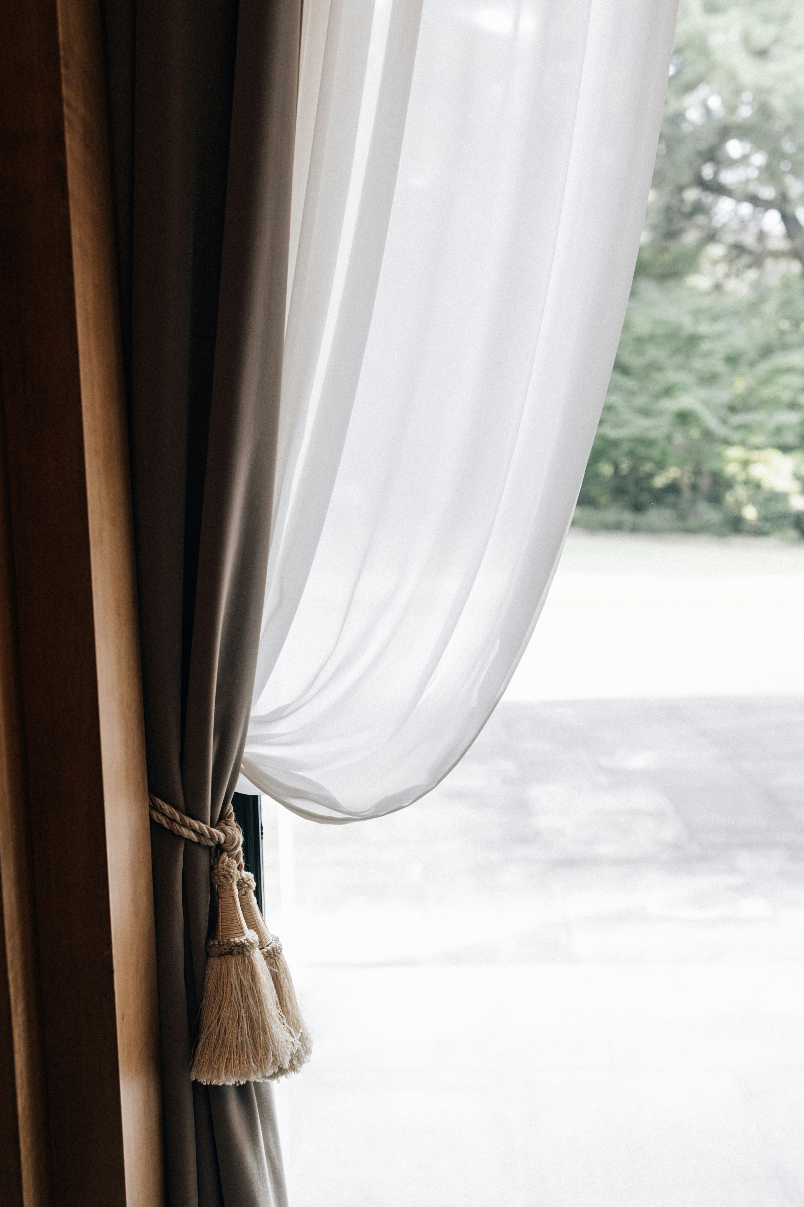 Drapes tied back with tassels by a window