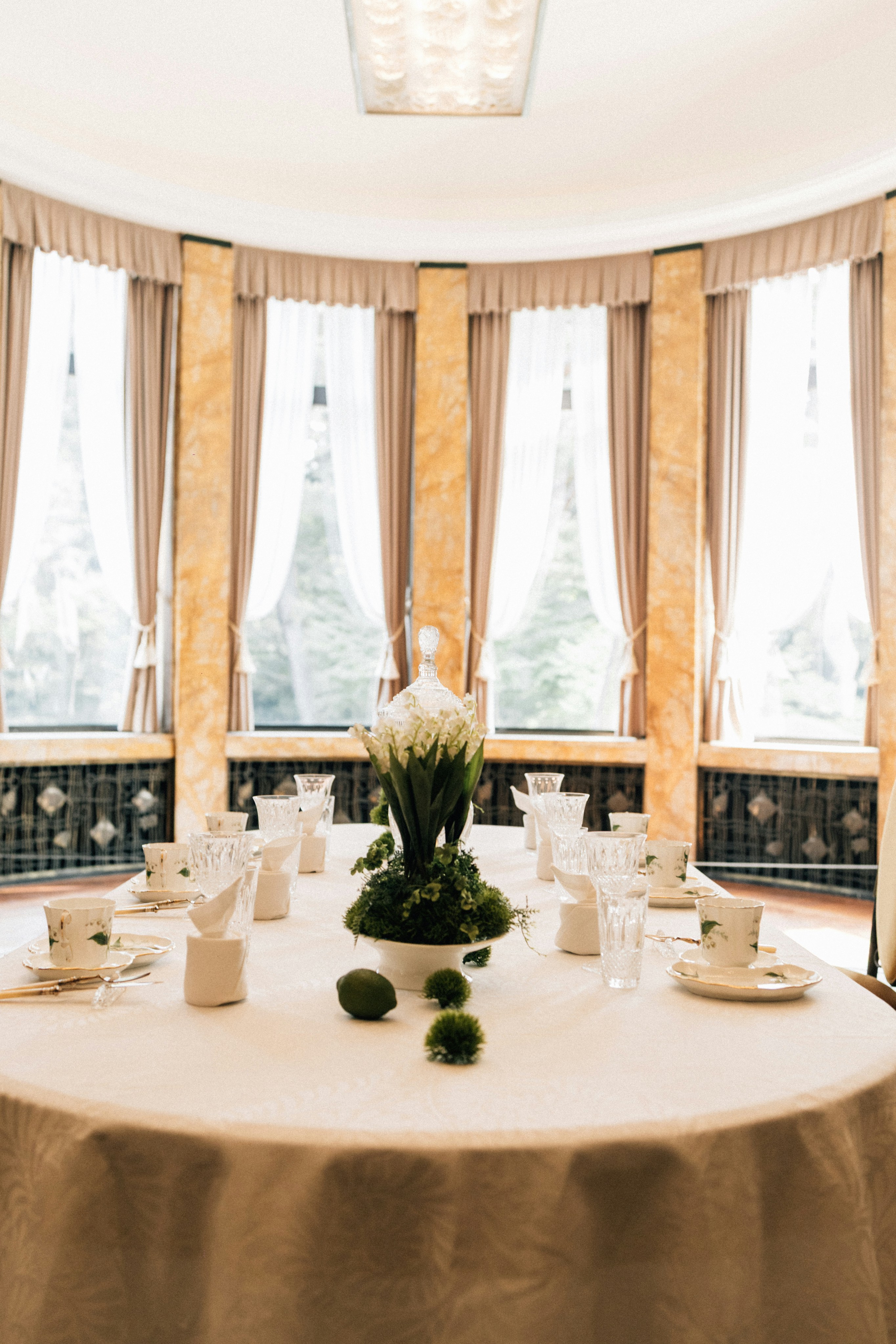 A round table set for tea with floral centerpiece.