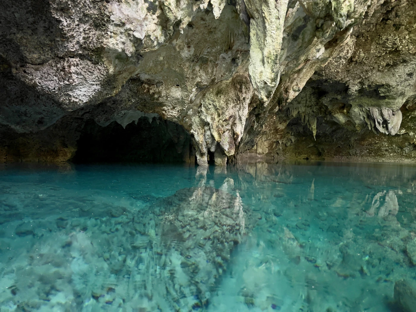 Crystal clear turquoise water in a cenote cave in the Yucatan Mexico showing the underground freshwater sinkhole with its distinctive blue-green water and cave formations