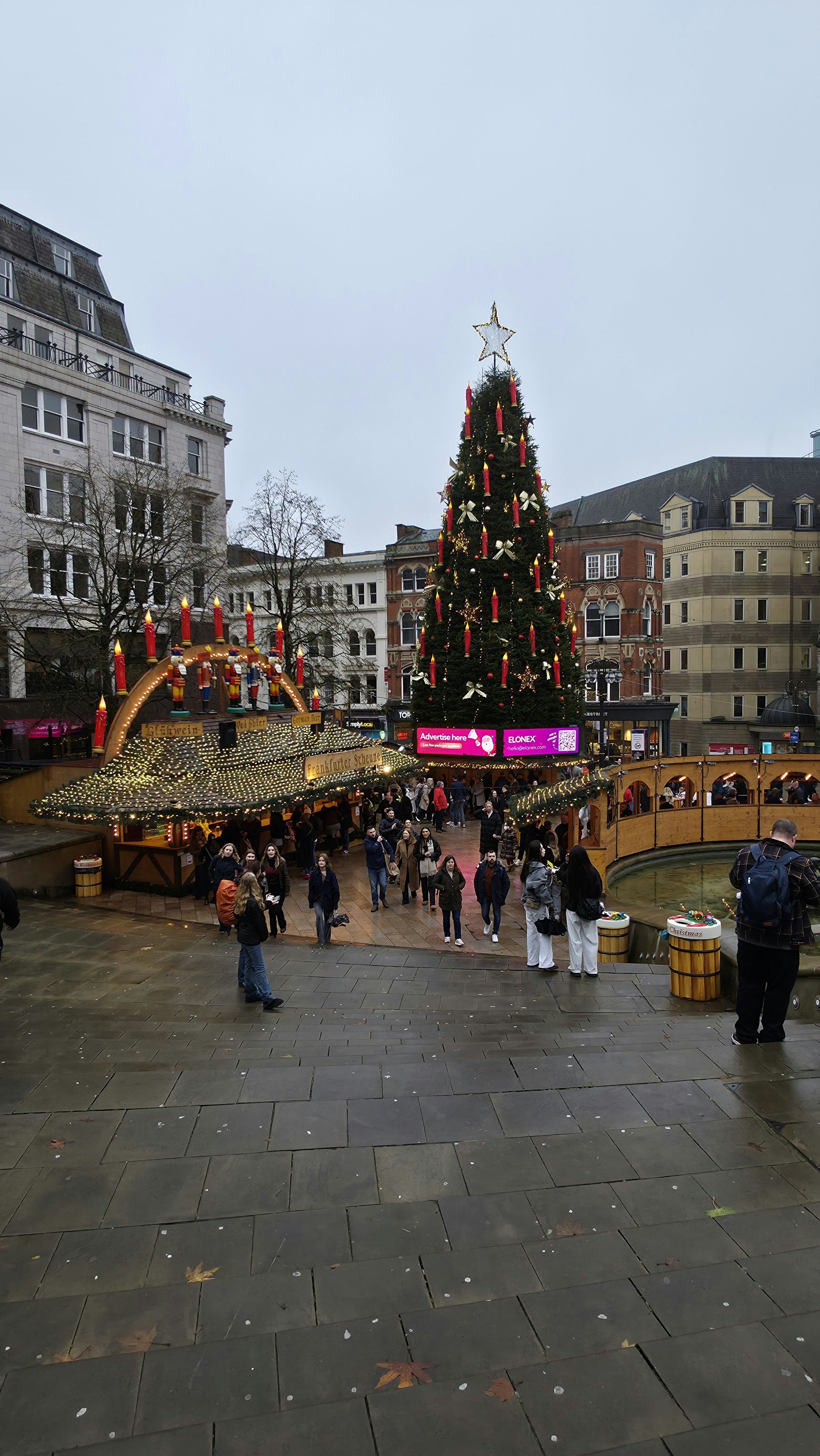 Christmas market with decorated tree and stalls.