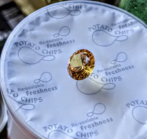 A faceted yellow gemstone on potato chip packaging.