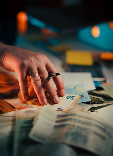 Hand reaching for euro banknotes, illustrating the financial stakes of dealer selection