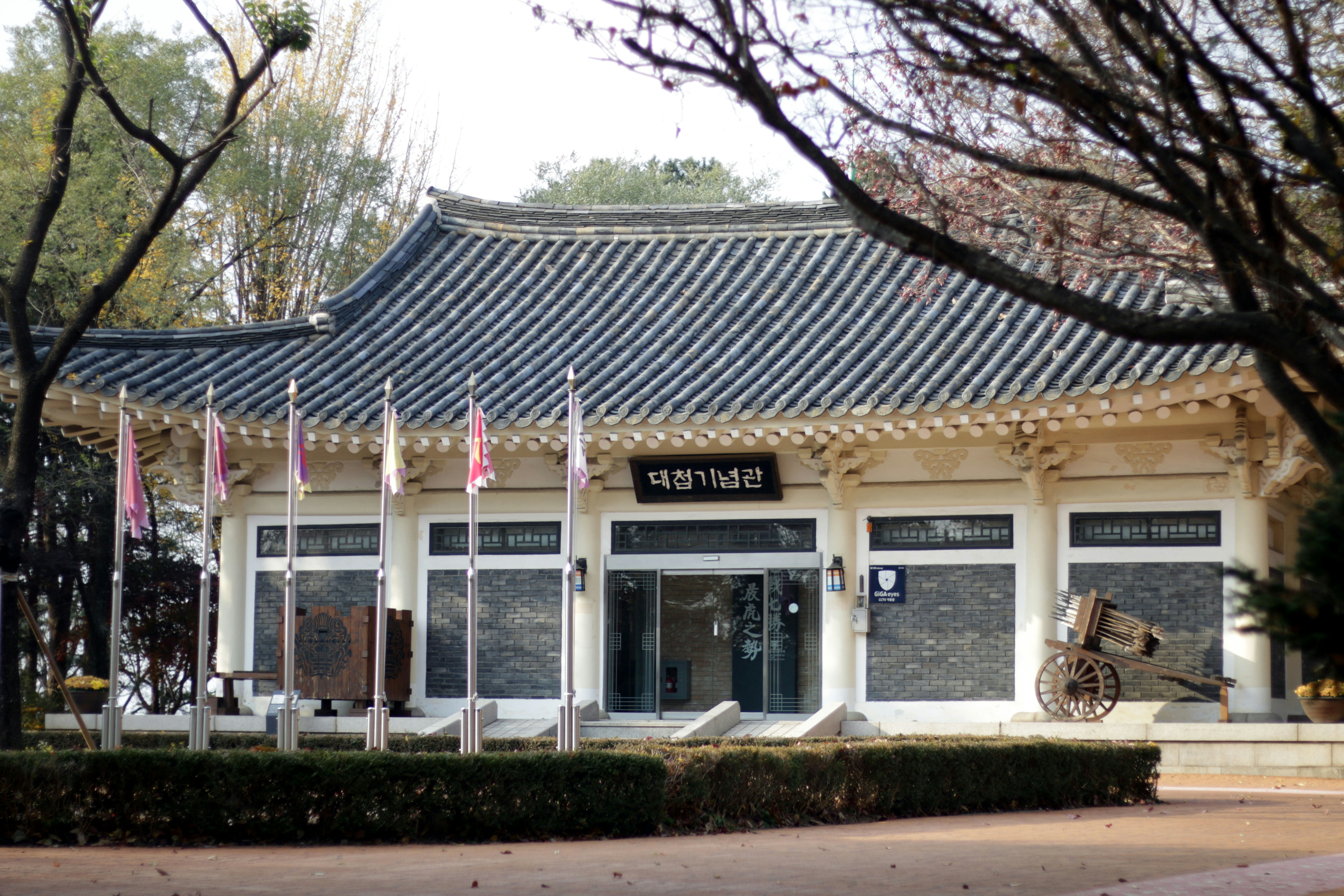 Traditional korean building with flags and cannon
