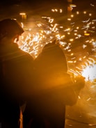 Two people watch fireworks explode in the night sky.