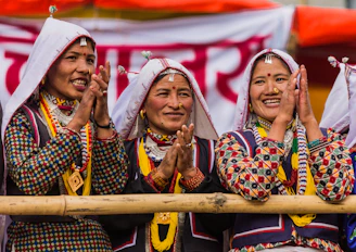 Three women in traditional clothing clapping