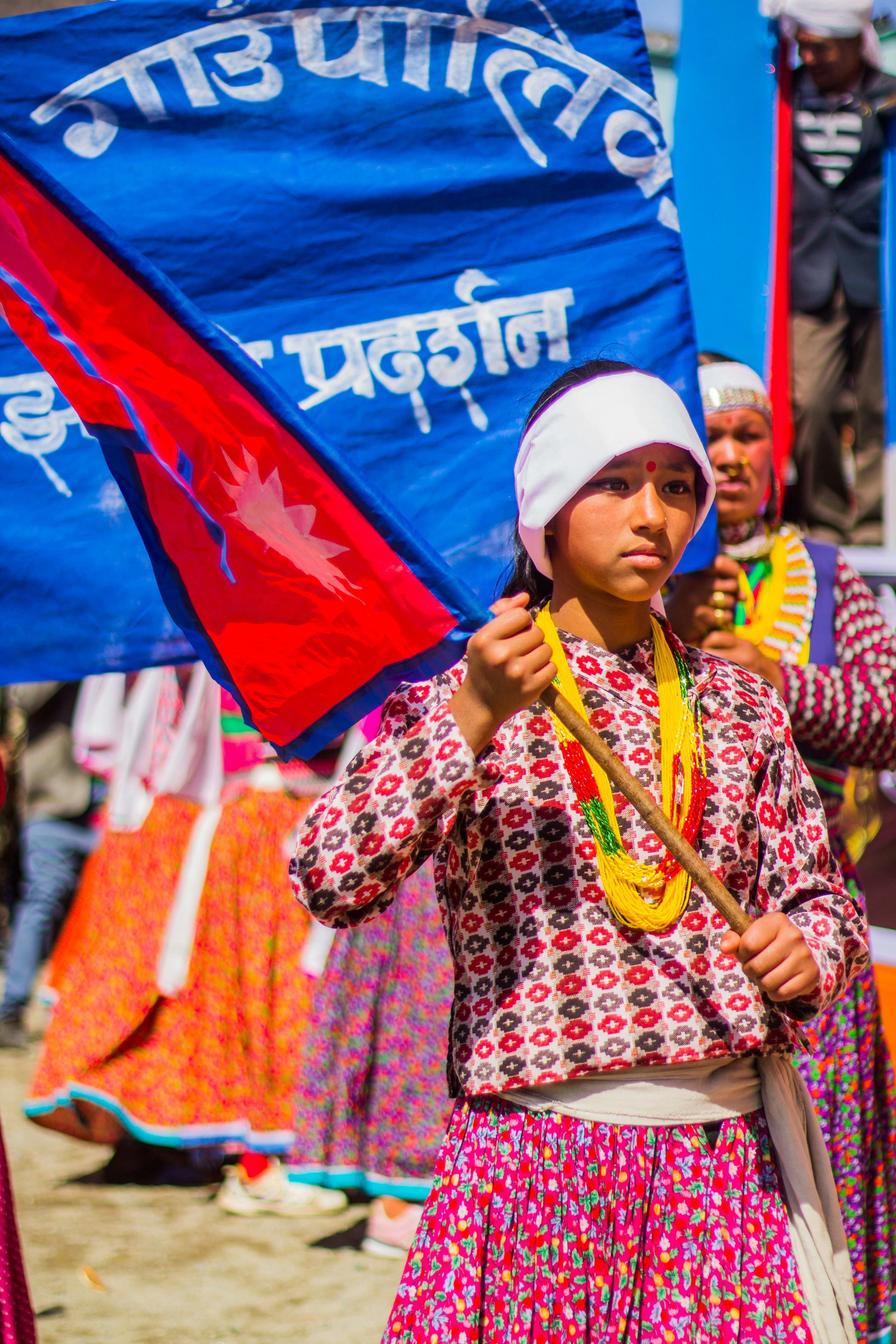 Young girl holds nepalese flag during a celebration.