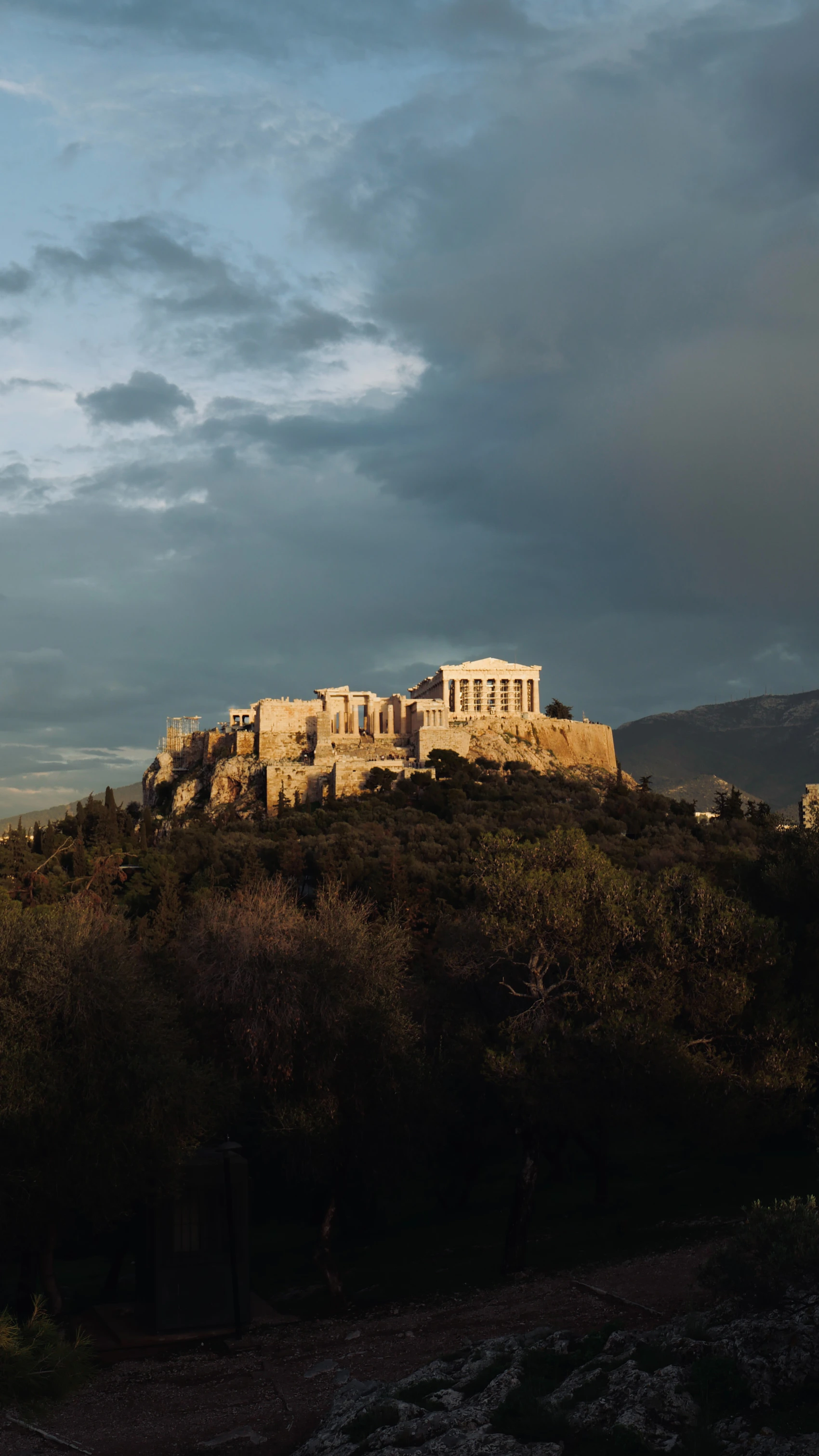 The Parthenon and Acropolis glowing in golden light above Athens