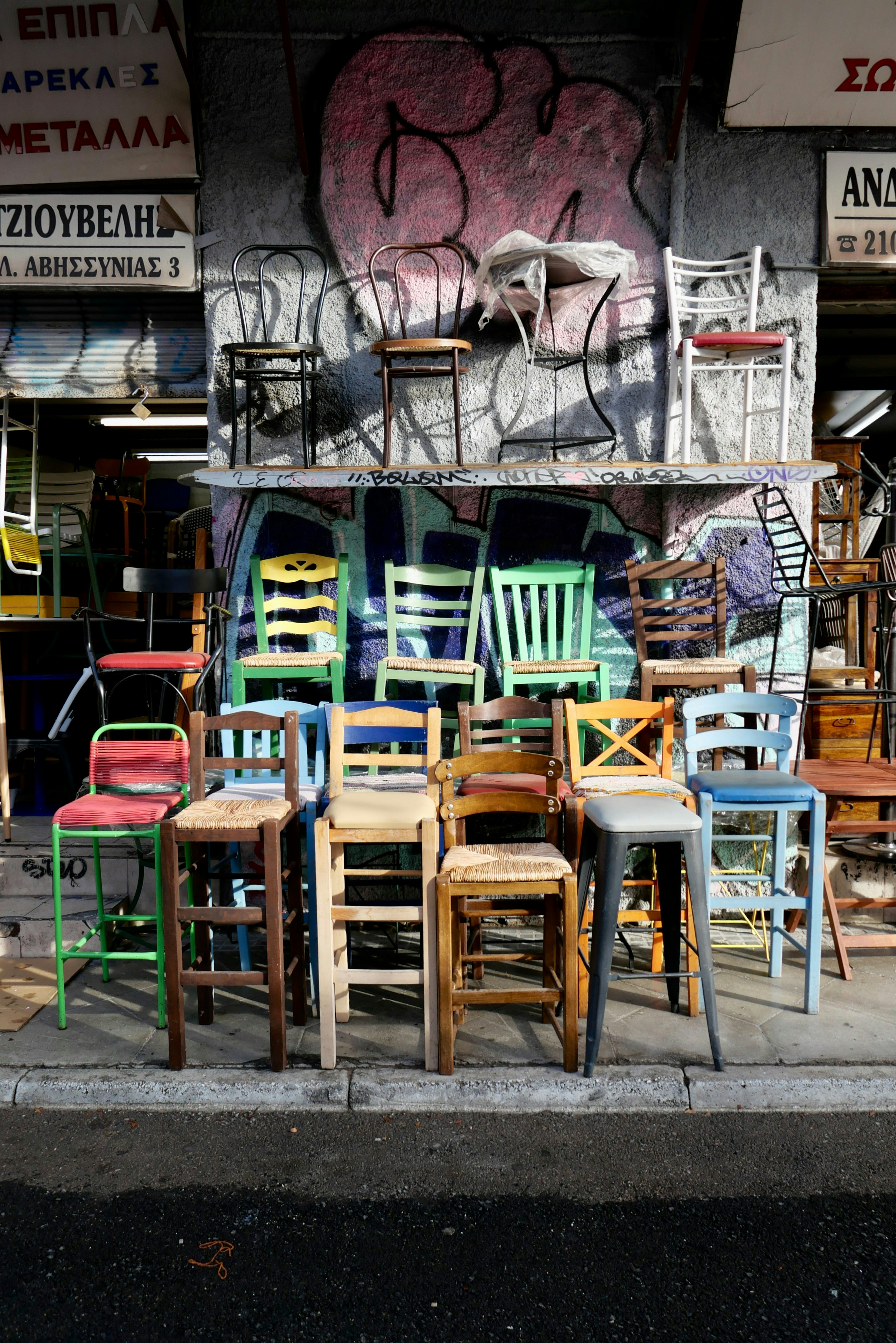 Assortment of colorful chairs lined up outdoors.