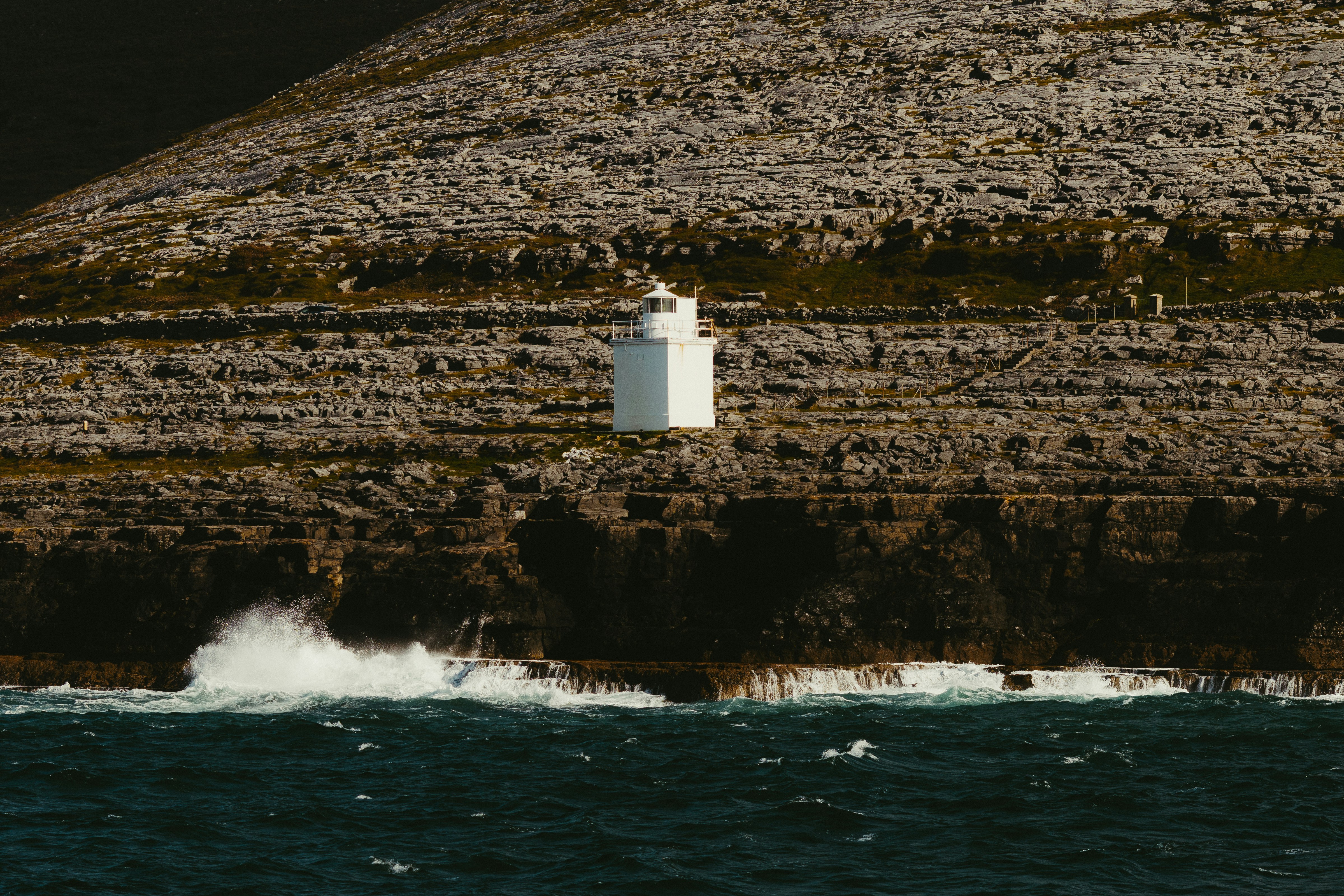 White lighthouse on a rocky cliff by the ocean