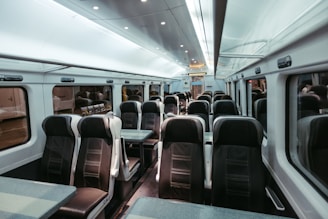 Empty train carriage with rows of seats and tables