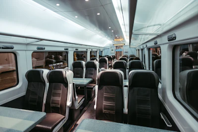Empty train carriage with rows of seats and tables