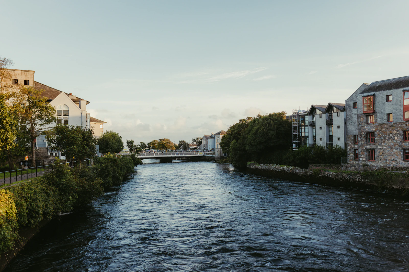 River flowing between buildings under a clear sky