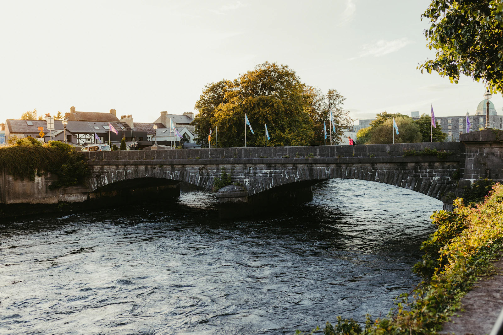 Stone bridge over a flowing river at sunset
