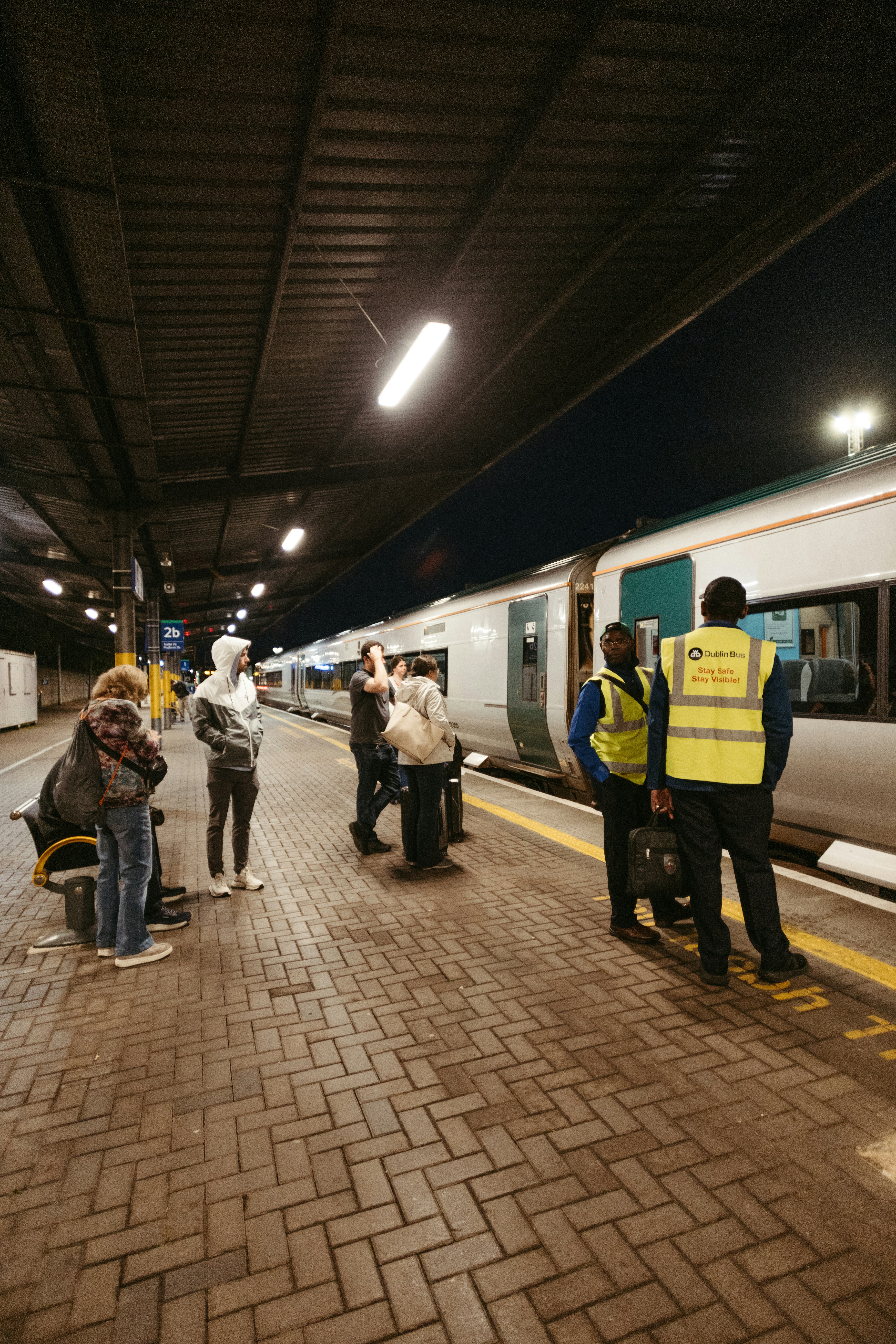 Leute, die nachts auf einem Bahnsteig warten.