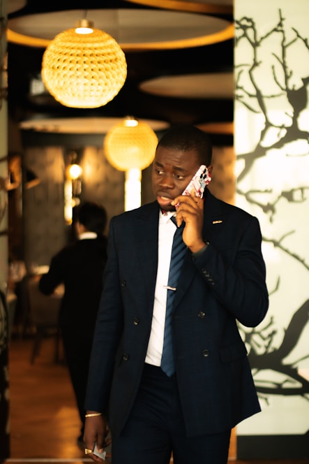 Man in suit talking on phone in restaurant