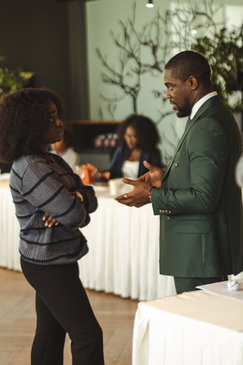 Two professionals talking in a meeting room.