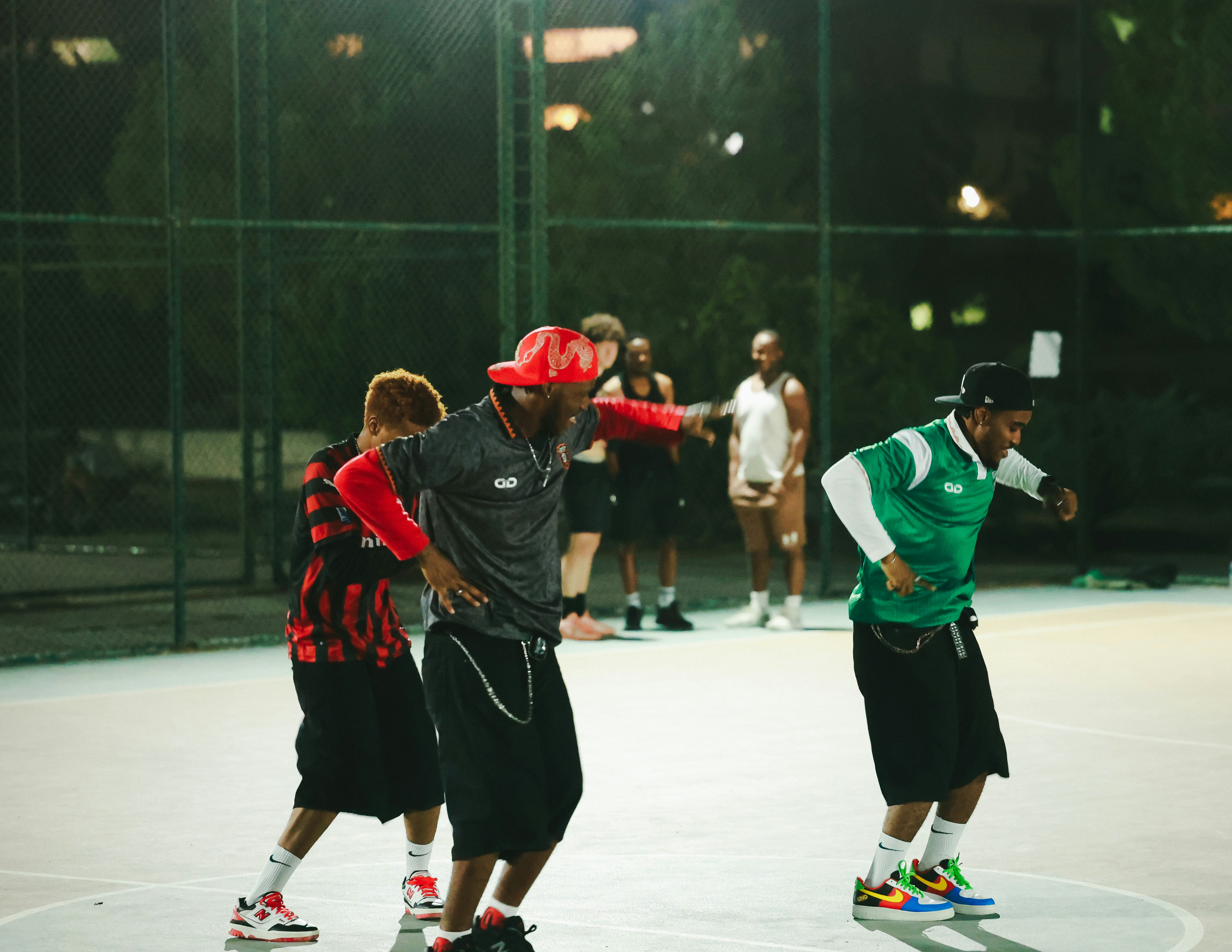Männer, die nachts auf einem Basketballplatz im Freien tanzen