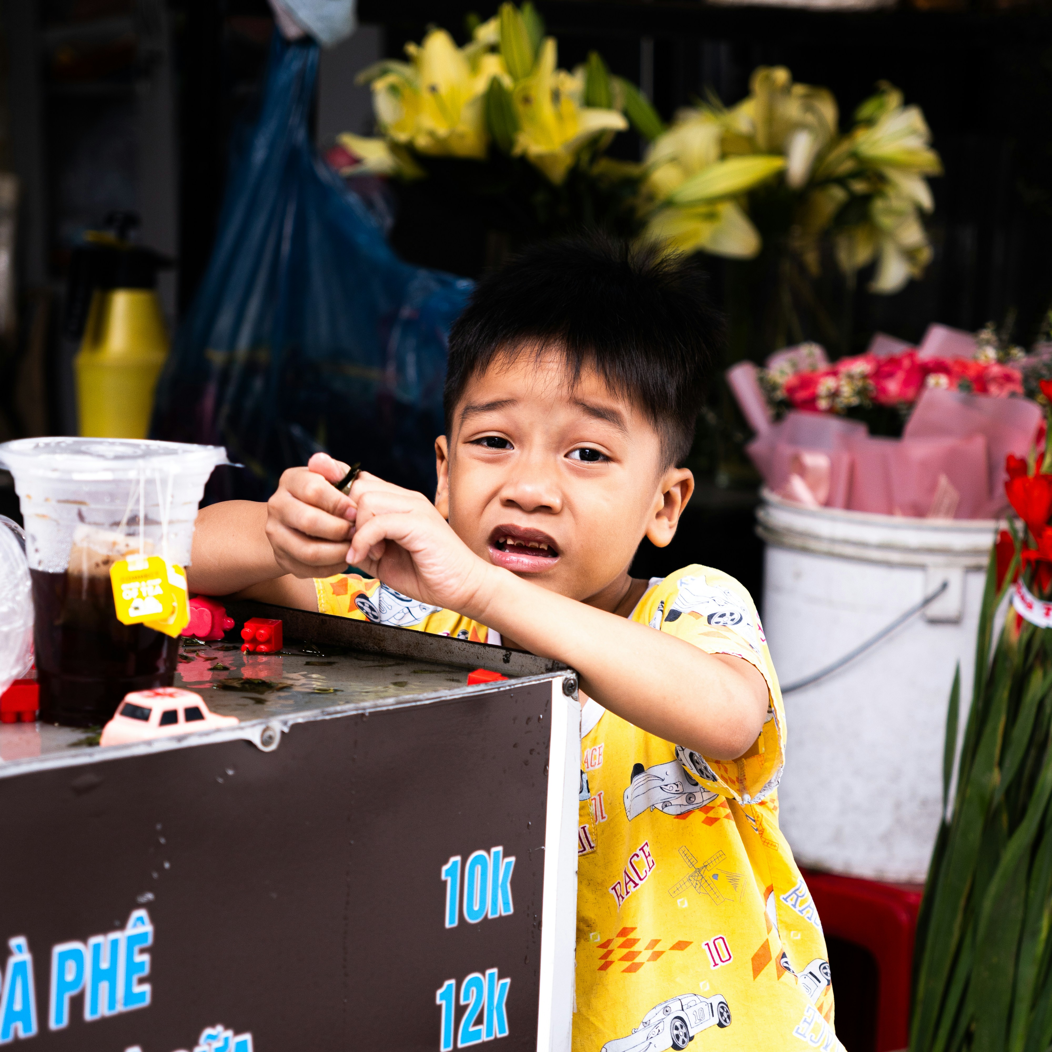 Junger Junge mit traurigem Gesichtsausdruck an einem Straßenstand.