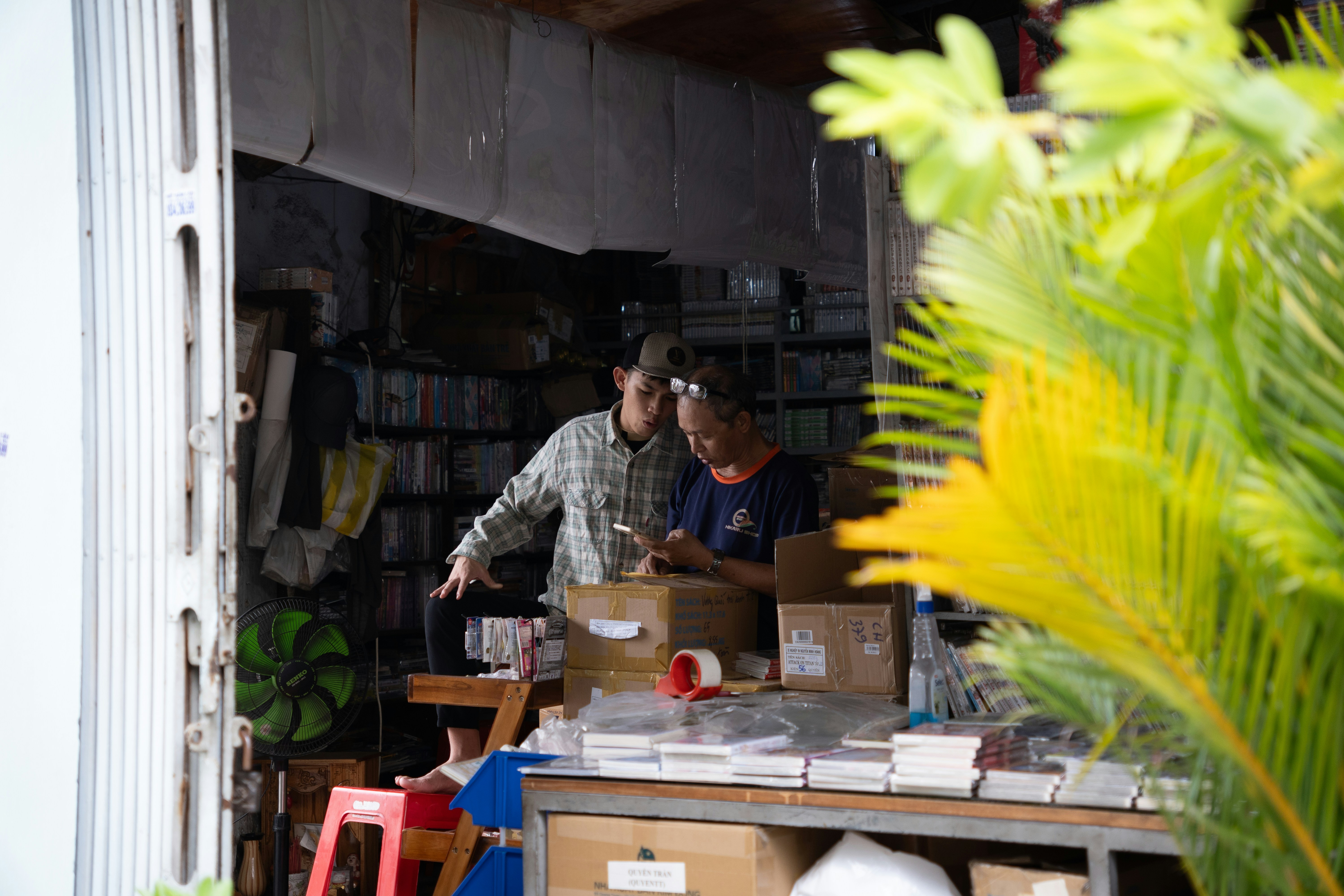 Two people working in a cluttered store.