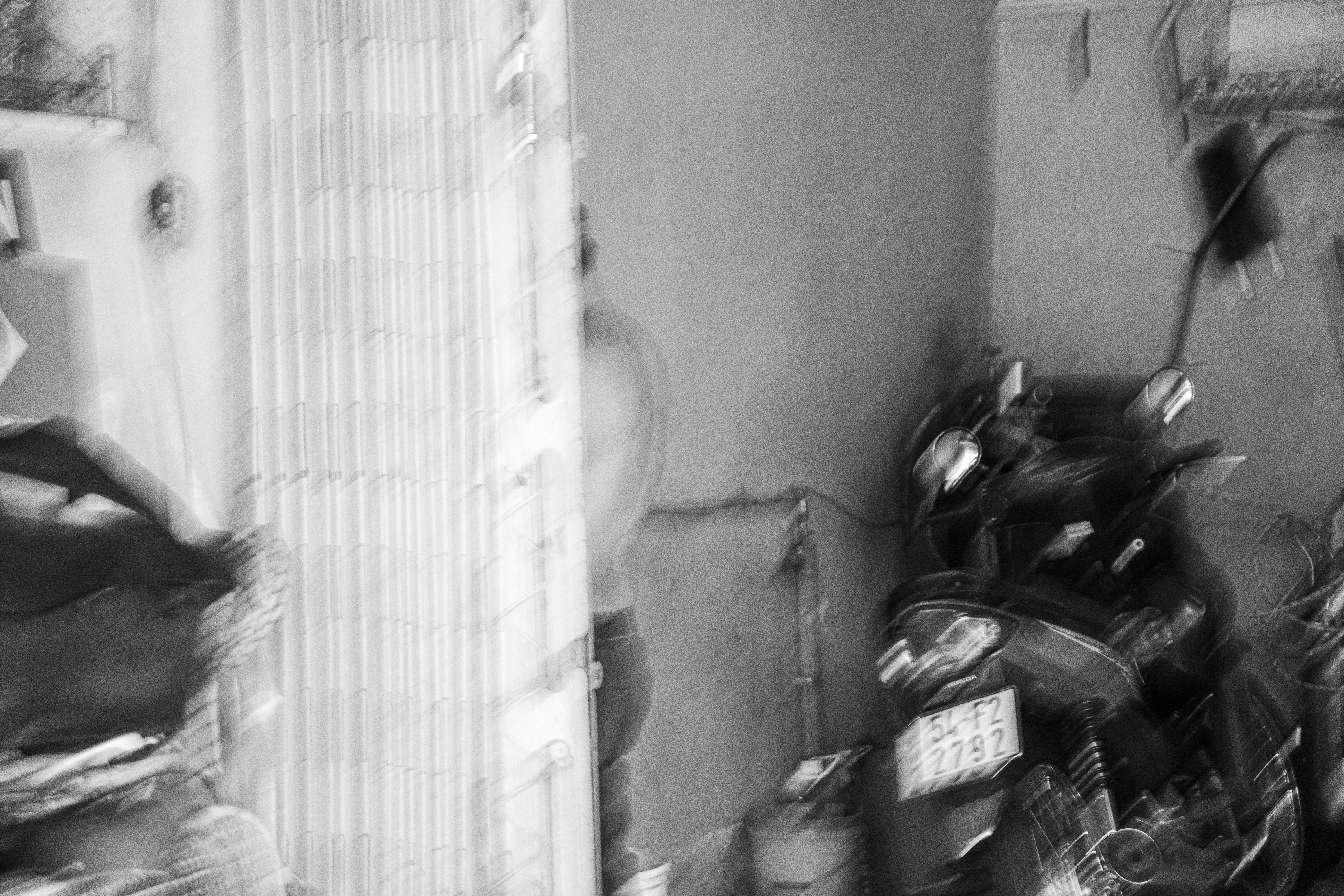 Blurry black and white interior with motorcycle.