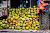 A large pile of fresh coconuts at a market stall.