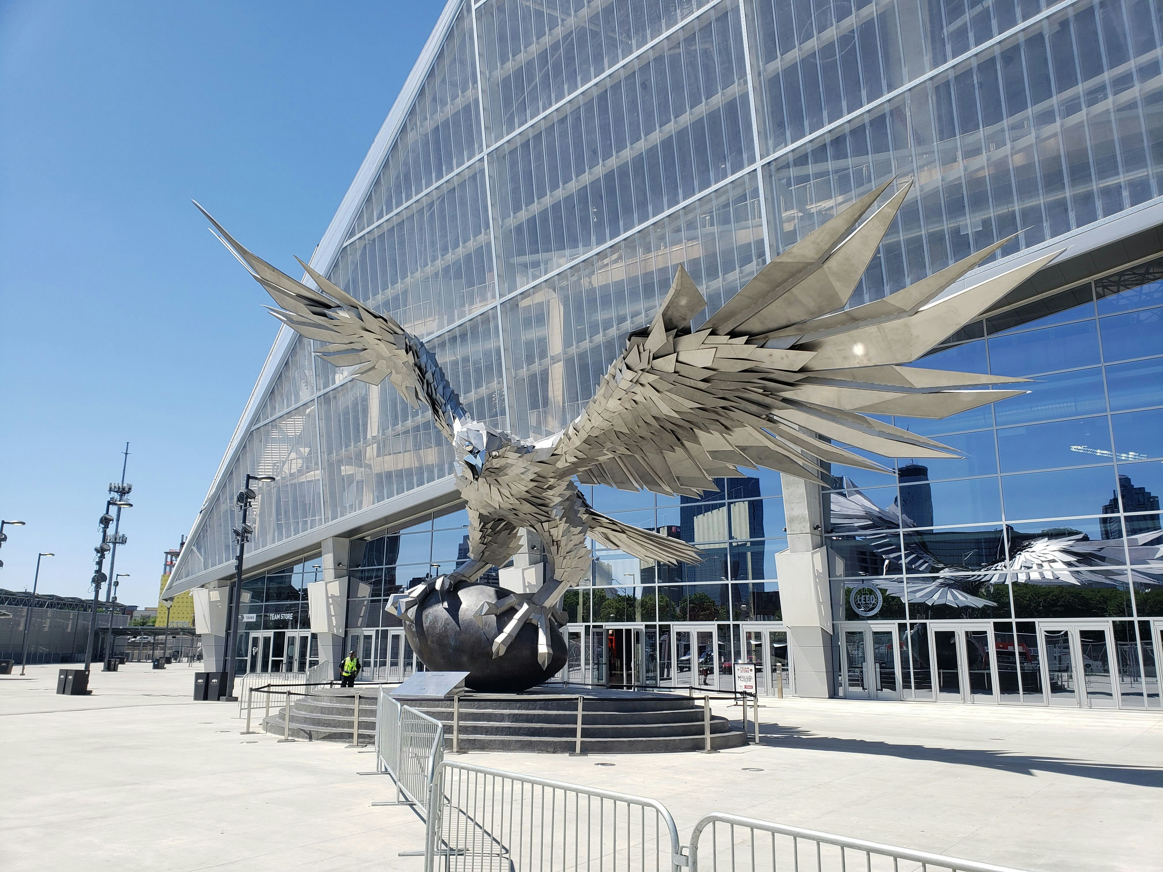 Large metallic eagle sculpture outside modern building