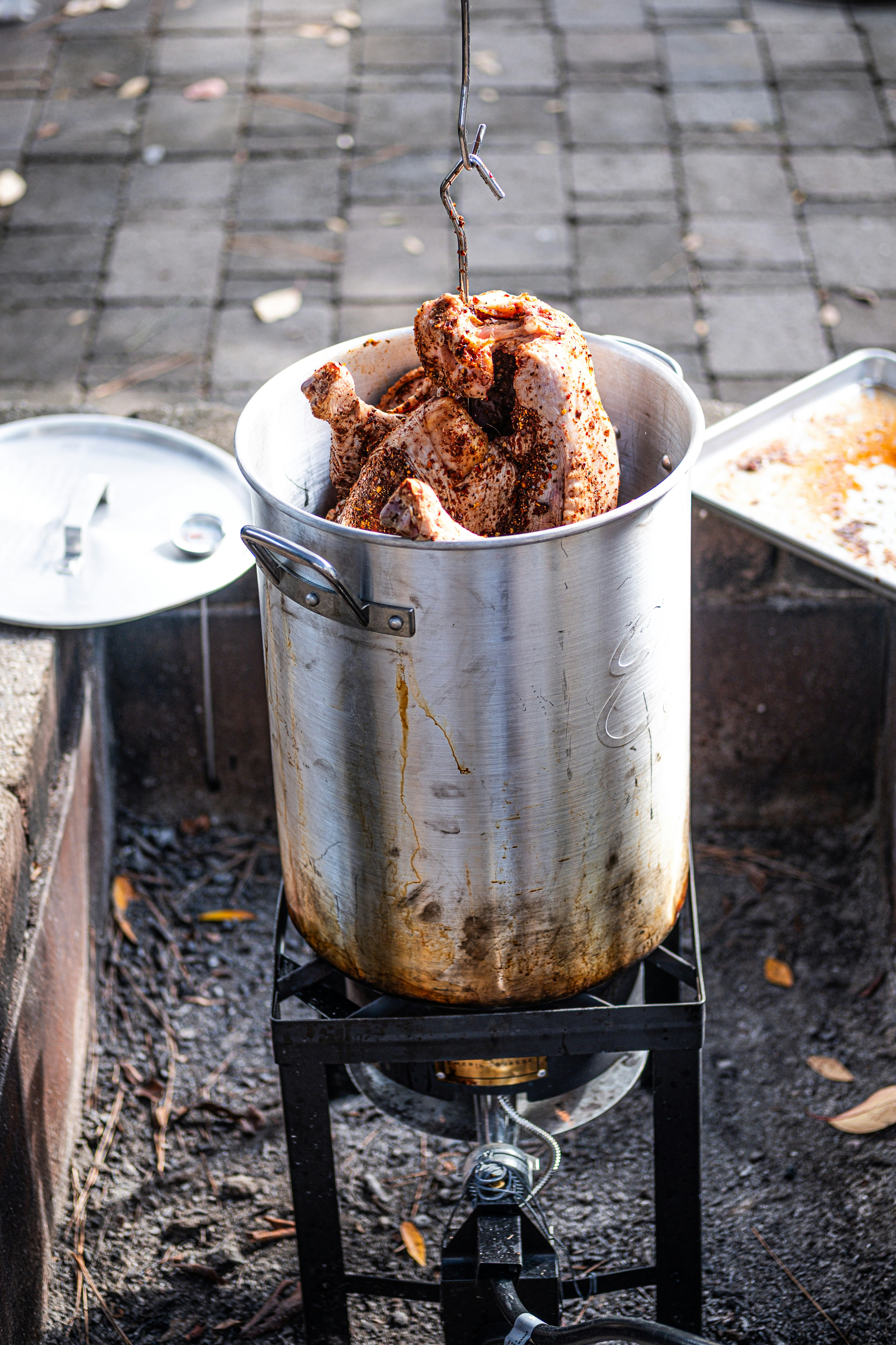 Whole chicken being lowered into a large pot.
