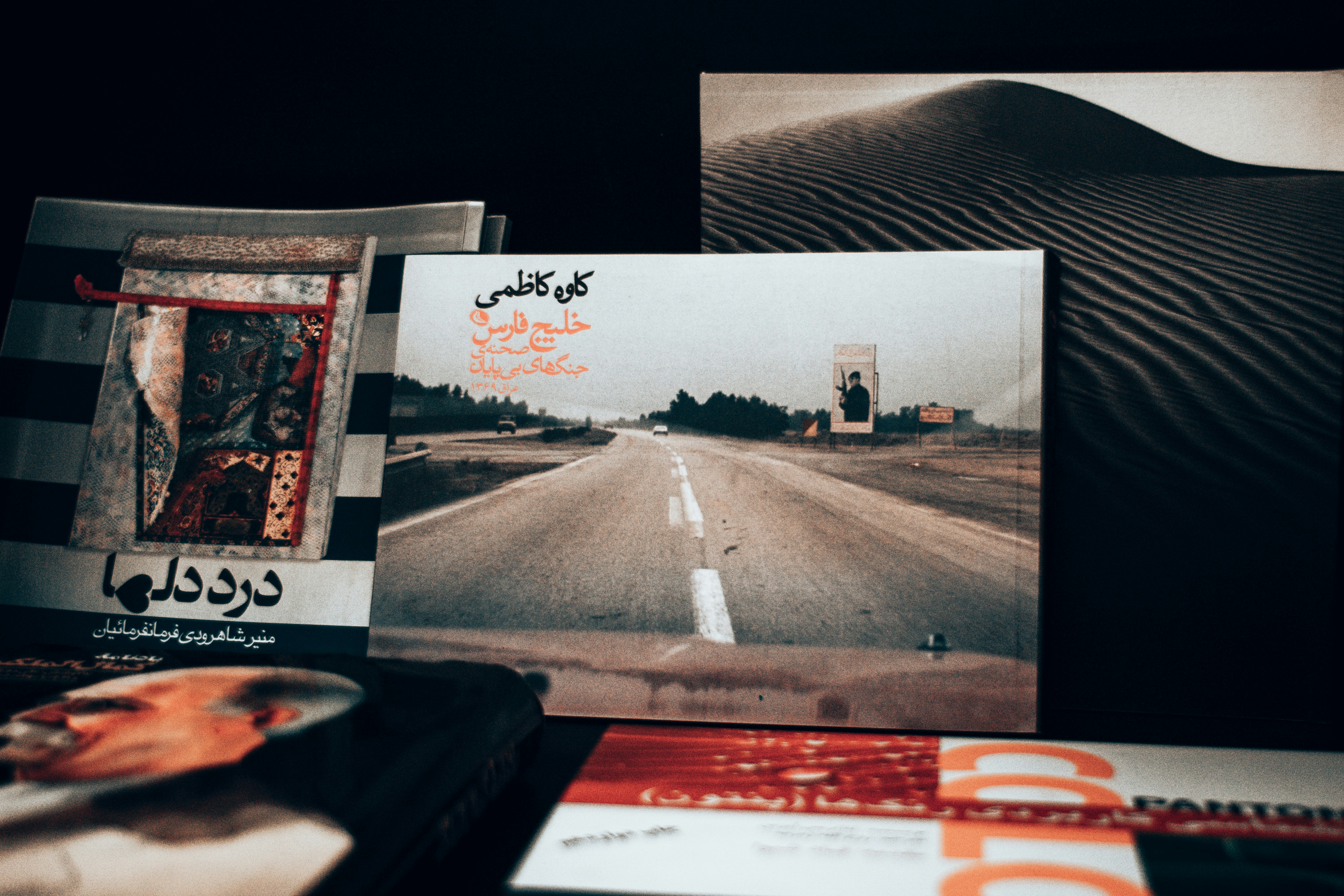Collection of books and artwork on a dark surface