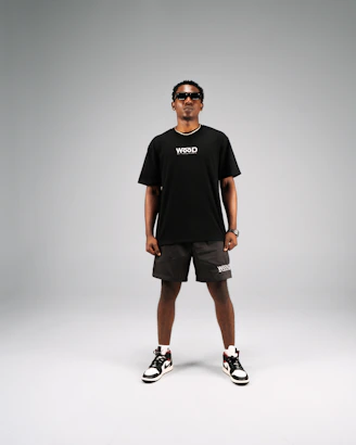 Man in black t-shirt and shorts with sunglasses.