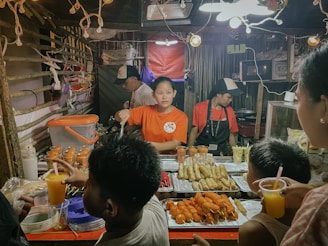 People buying food at a street food stall