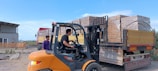 Forklift loading bricks onto a truck outdoors