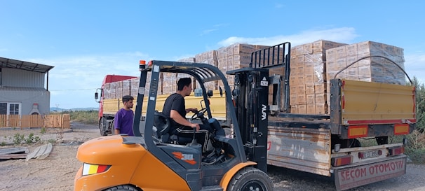 Forklift loading bricks onto a truck outdoors