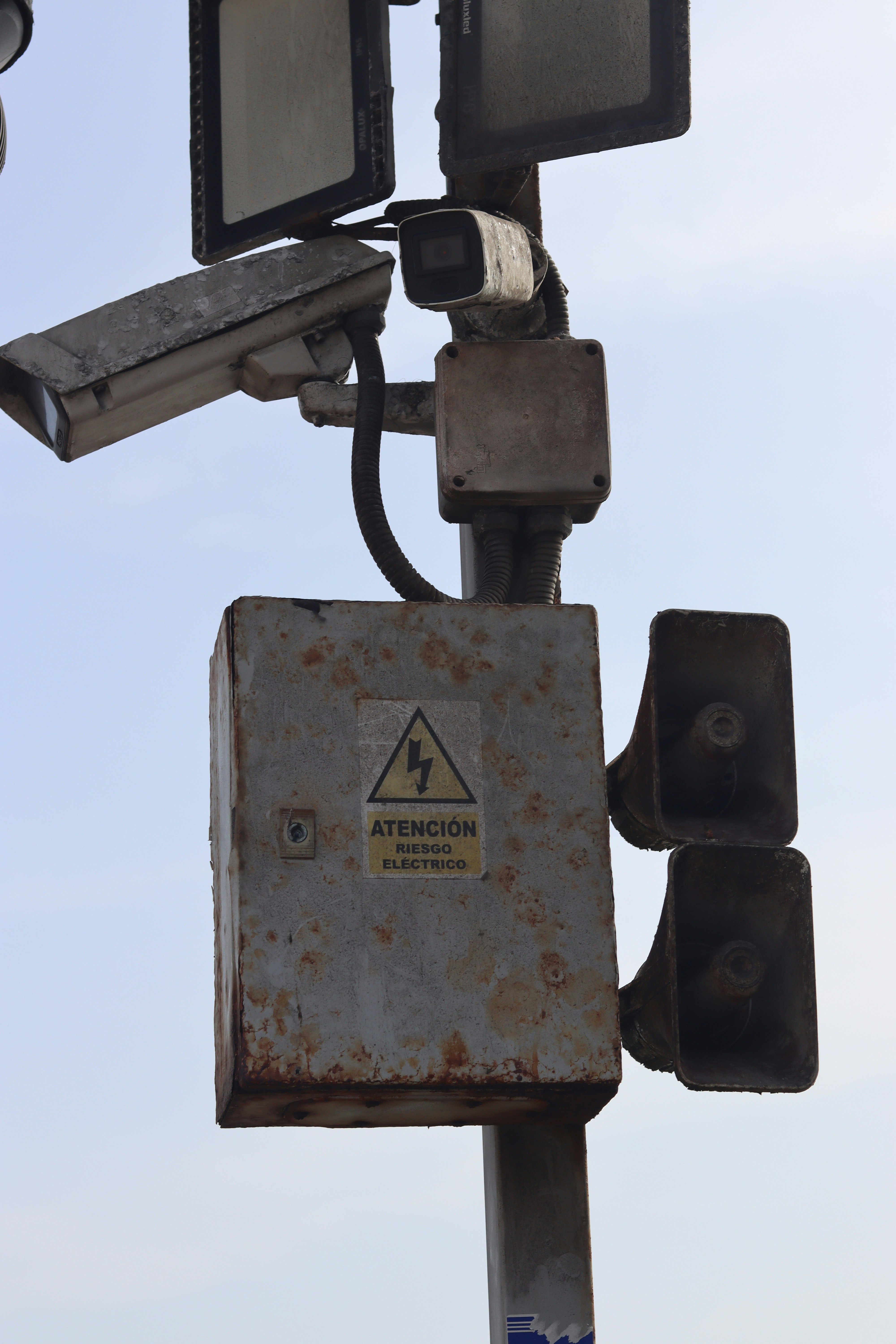 Security cameras and electrical warning sign on pole