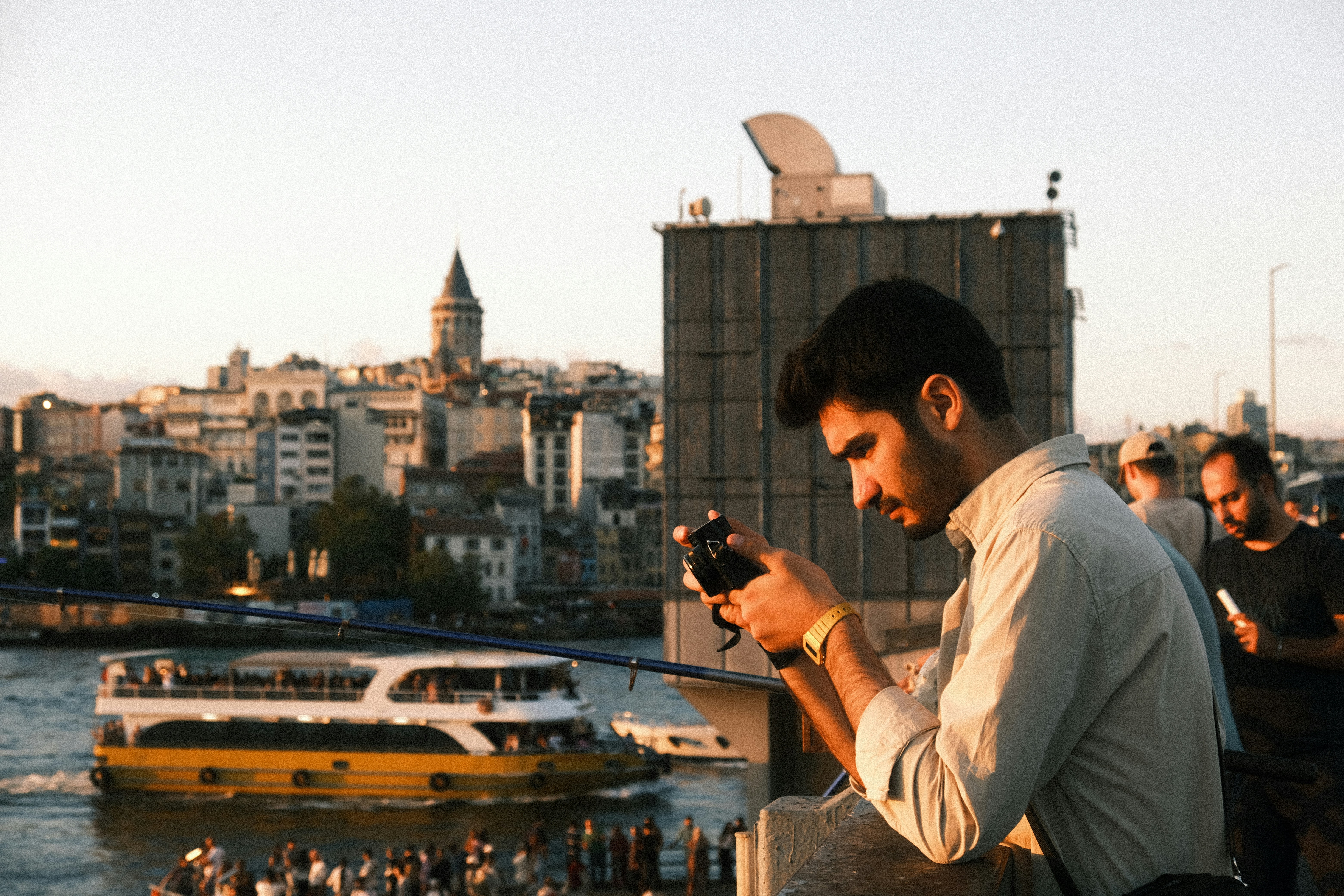 Traveler taking photos on Istanbul’s Galata Bridge with a phone