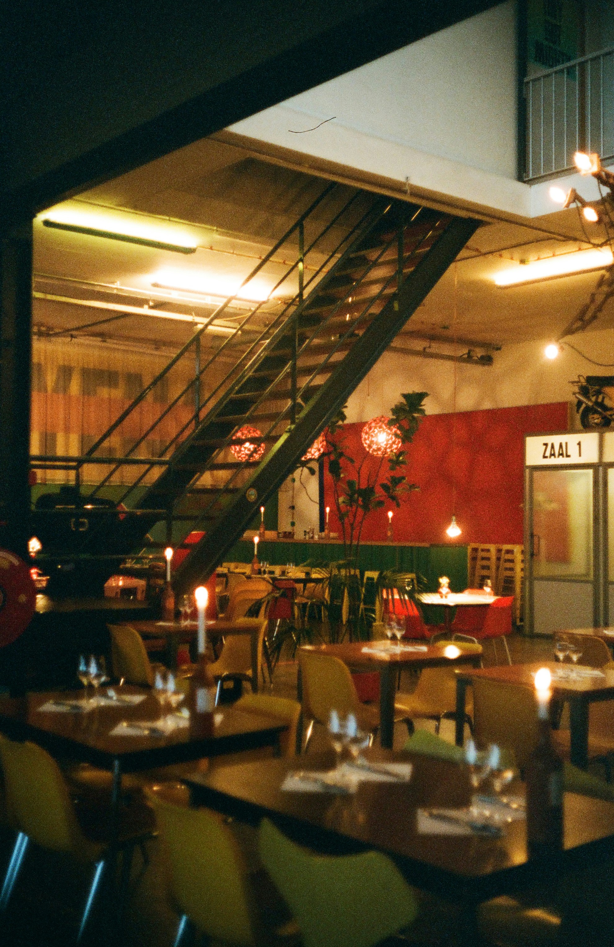 Restaurantinnenausstattung mit Tischen, Stühlen und Treppe.