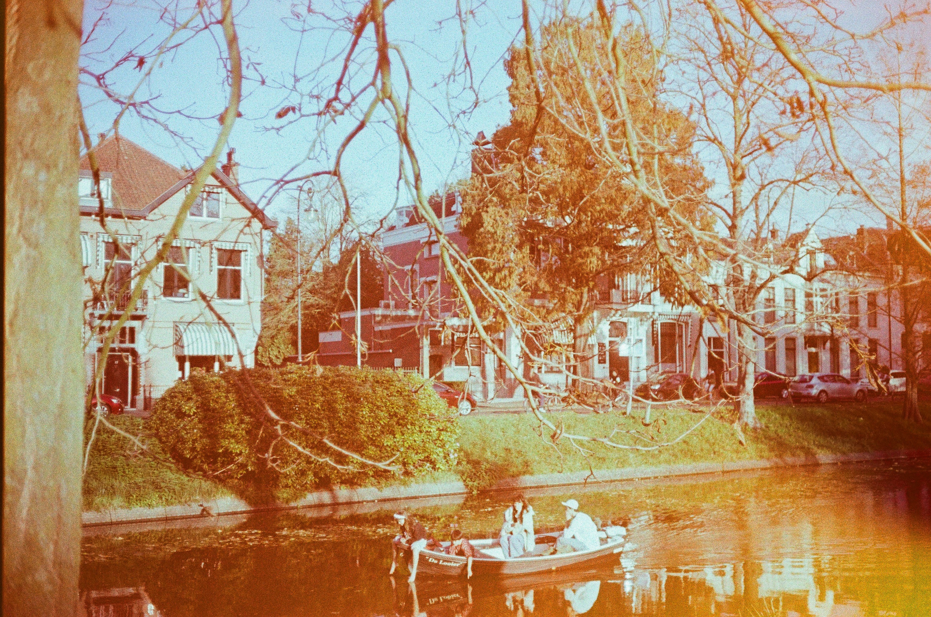 Menschen in einem Boot auf einem Kanal mit Gebäuden dahinter