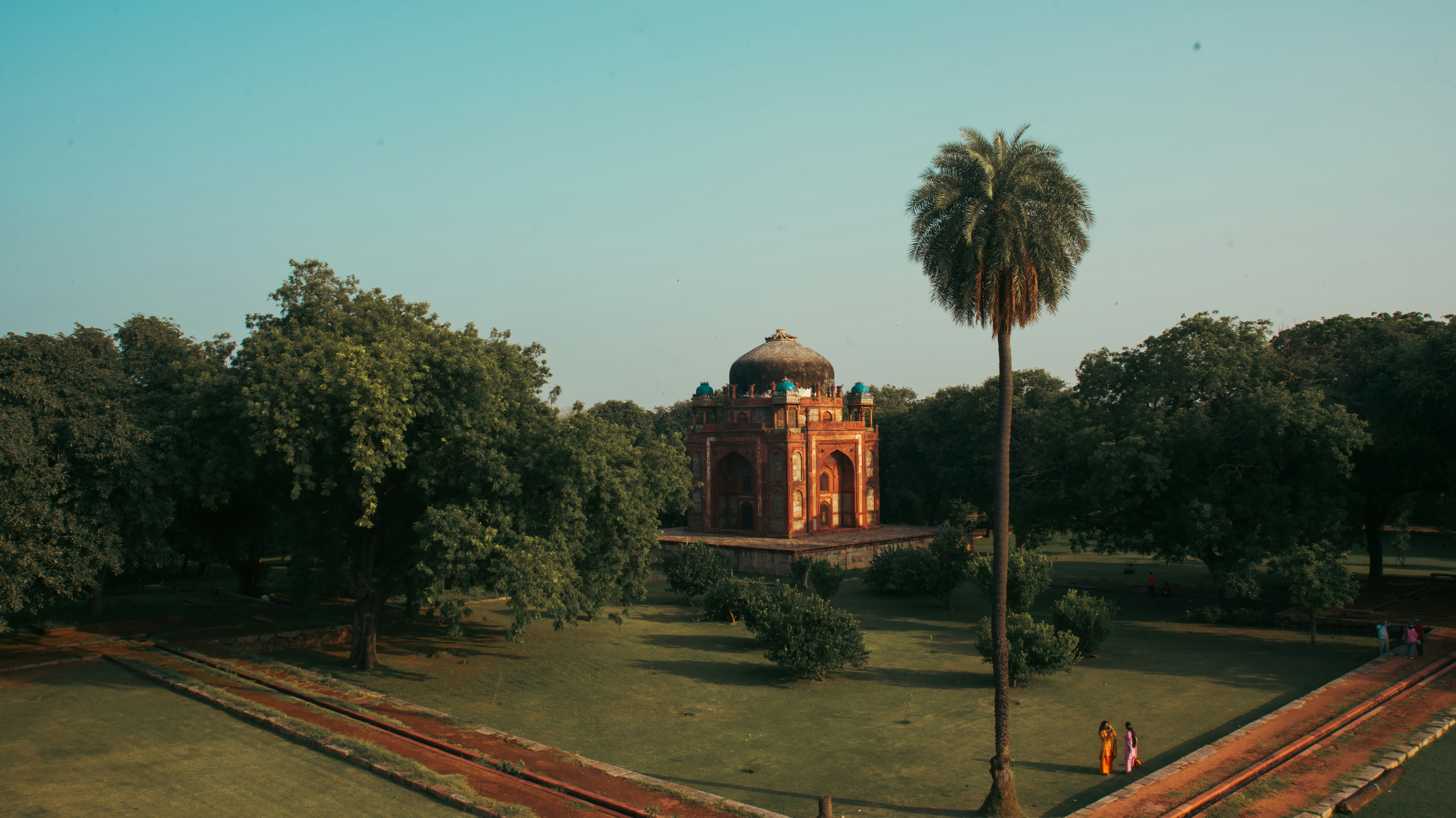 Ancient tomb surrounded by lush green trees and pathways